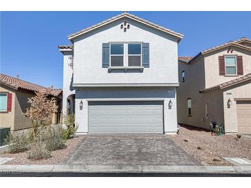Charming two-story home with a gray stucco exterior, two car garage, and a well-maintained brick driveway at 7256 Saxby Ave, Las Vegas, NV 89113