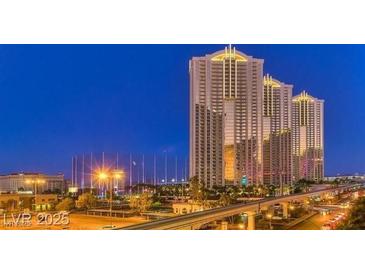 Modern luxury high-rise condominiums with lighted spires overlooking the city skyline at dusk at 125 E Harmon Ave # 717, Las Vegas, NV 89109