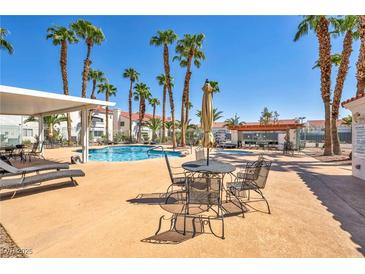 Community pool surrounded by palm trees and lounge chairs at 2725 S Nellis Blvd # 2052, Las Vegas, NV 89121