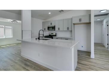 Bright kitchen boasts a large island, stainless appliances, modern cabinetry, and sleek fixtures at 4255 Breezy Point Ln, Las Vegas, NV 89115
