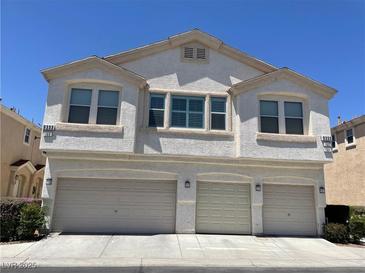 Inviting townhouse featuring a three-car garage and neutral-toned stucco exterior at 9333 Leaping Deer Pl # 103, Las Vegas, NV 89178