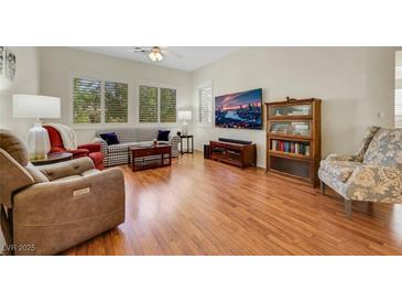 Bright living room with hardwood floors, large windows, and comfortable seating arrangement at 10532 Sea Palms Ave, Las Vegas, NV 89134