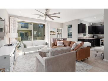 Open-concept living room with a ceiling fan, modern furniture, and lots of natural light from a large window at 11256 Rainbow Peak Ave # 202, Las Vegas, NV 89135