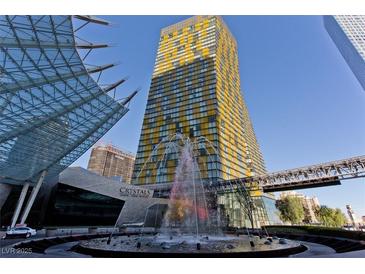 Eye-level exterior view of a yellow-striped high-rise with water fountain and glass architecture at 3726 Las Vegas Blvd # 1902, Las Vegas, NV 89158