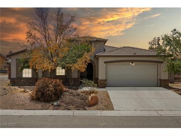 Charming single-story home features manicured landscaping and a spacious two-car garage at 565 Mazelle Ln, Pahrump, NV 89060