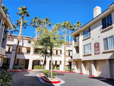 Inviting condo community featuring a beautifully maintained exterior and lush tropical landscaping with mature palm trees at 7135 S Durango Dr # 314, Las Vegas, NV 89113