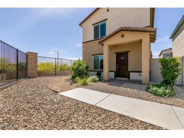 Two-story home featuring a gated front yard and a covered entryway with brick-paved accents at 7302 Sunray Point St, North Las Vegas, NV 89084