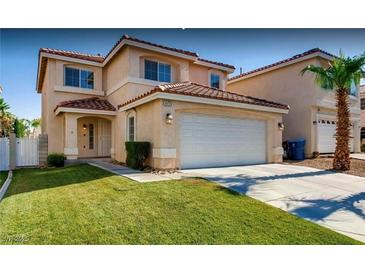 Charming stucco home with a red tile roof, a well-manicured lawn, and a two-car garage at 9773 Sonora Bend Ave, Las Vegas, NV 89148