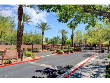 Gated community entrance with palm trees and manicured landscaping creates a welcoming environment at 1001 Domnus Ln # 201, Las Vegas, NV 89144