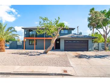Two-story home featuring a balcony, desert landscaping, and attached two-car garage at 2180 Palora Ave, Las Vegas, NV 89169