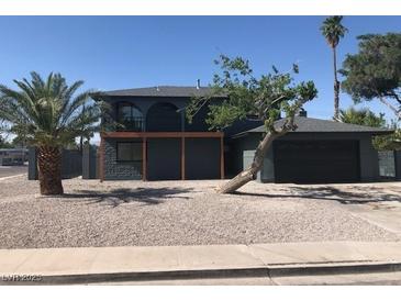 Charming two-story home with a desert landscaped yard, covered deck, and a large palm tree at 2180 Palora Ave, Las Vegas, NV 89169