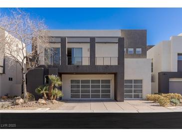 Modern two-story home featuring a two-car garage, balcony, and minimalist landscaping at 2672 Mystere Ct, Las Vegas, NV 89117