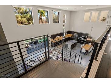 Open-concept living space with modern kitchen, dining area, and view of the pool from the second story at 2672 Mystere Ct, Las Vegas, NV 89117