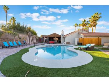 Sparkling pool with lush landscaping, covered patio, and lounge seating for outdoor enjoyment at 3099 Palmdesert Way, Las Vegas, NV 89120