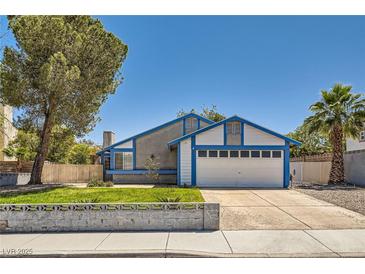 Charming two-story home featuring a two-car garage and manicured front lawn on a sunny day at 318 Heather Dr, Henderson, NV 89002