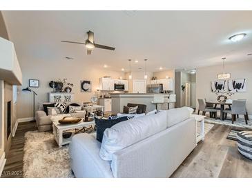 Bright, open-concept living area with a ceiling fan, stylish furnishings, and hardwood flooring at 4521 Bell Cord Ave # 103, North Las Vegas, NV 89031