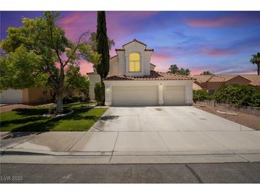 Charming home featuring a three car garage, mature landscaping, and a classic red tiled roof at 4521 Crimson Leaf Dr, Las Vegas, NV 89130