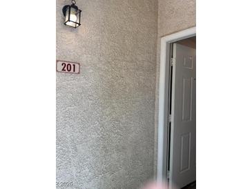 Apartment 201 features a textured exterior wall with a sconce and a white door at 541 Indian Bluff St # 201, Las Vegas, NV 89145