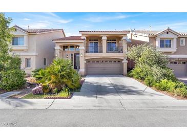 Two-story home featuring a front-facing two car garage, balcony, and well maintained landscaping at 6726 Glissando Ct, Las Vegas, NV 89139