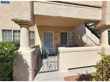 Inviting front entrance with gated access, covered porch, and well-maintained landscaping at 8410 Eldora Ave # 1053, Las Vegas, NV 89117