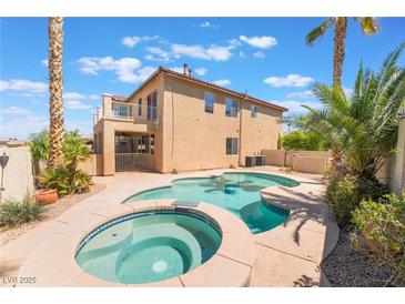 Inviting backyard pool and spa surrounded by lush landscaping, ideal for relaxation and outdoor enjoyment at 395 Suzanne Peak Ct, Henderson, NV 89012