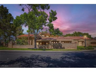 Charming single-story home featuring a red tile roof and mature landscaping at 7296 Mission Hills Dr, Las Vegas, NV 89113