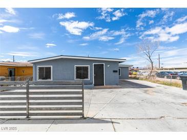 Charming single-story house featuring a gray exterior, a large front yard, and off-street parking at 1013 Cunningham Dr, Las Vegas, NV 89106