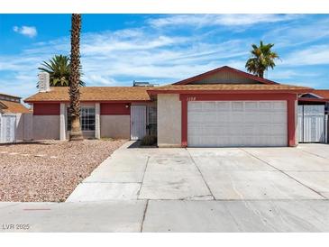 Single-story home featuring a two-car garage, desert landscaping, and a red and beige exterior at 1158 E Hacienda Ave, Las Vegas, NV 89119