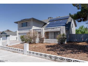 Two-story home featuring stucco exterior, solar panels, and a well-maintained front yard at 3061 Brockington Dr, Las Vegas, NV 89120