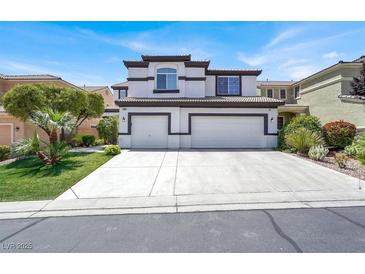 Two-story home featuring a three-car garage, stucco exterior, and a well-manicured lawn at 5785 Farmhouse Ct, Las Vegas, NV 89141