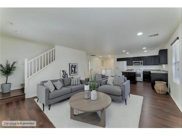 Bright living room featuring modern decor, hardwood floors, and a staircase, creating an inviting atmosphere at 6485 Arrow Cottage Ct, Las Vegas, NV 89130