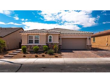 Inviting single-story home with stone accents, lush landscaping, and a two-car garage at 7525 Campbell Ranch Ave, Las Vegas, NV 89179