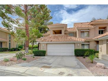 Charming townhouse featuring a two-car garage and manicured landscaping at 8591 Heather Downs Dr, Las Vegas, NV 89113