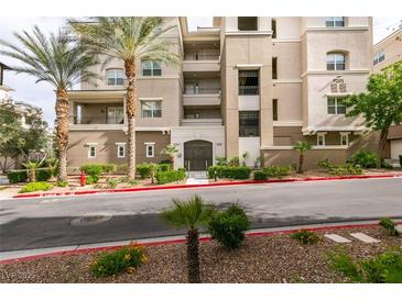 Beautiful condo building featuring manicured landscaping and mature palm trees at 9201 Tesoras Dr # 302, Las Vegas, NV 89144
