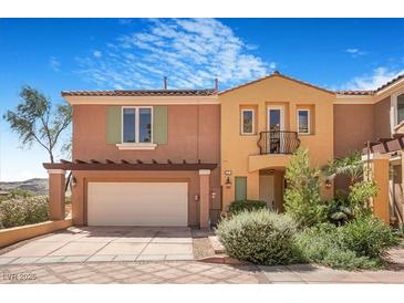Charming townhome featuring stucco siding, an attached two-car garage, and well-manicured landscaping at 1 Cerchio Basso, Henderson, NV 89011