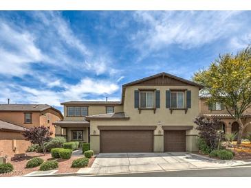 Two-story home boasts a multi-car garage, complemented by charming shutters and landscaped front yard at 10623 Auburn Springs Ave, Las Vegas, NV 89166