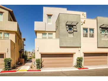 Modern townhome exterior with individual garages, desert landscaping and neutral color palette at 1275 Ice Park St # 101, Las Vegas, NV 89135