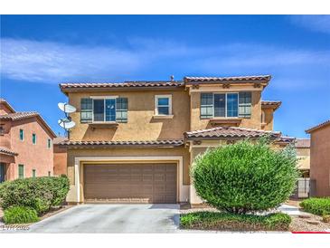 Two-story home featuring a tiled roof, a two-car garage, desert landscaping, and shuttered windows at 1420 Gilbert Creek Ave, North Las Vegas, NV 89031