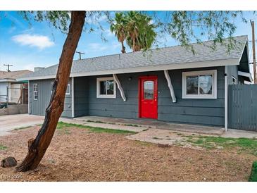 Cozy single-story home with gray siding, white trim and a bright red front door at 3412 Tabor Ave, North Las Vegas, NV 89030