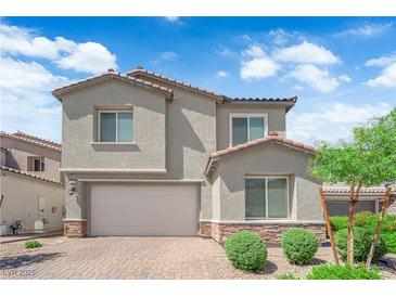 Charming two-story home with a brick driveway, two-car garage, and well-maintained landscaping at 4428 Mural Glen Ct, North Las Vegas, NV 89084