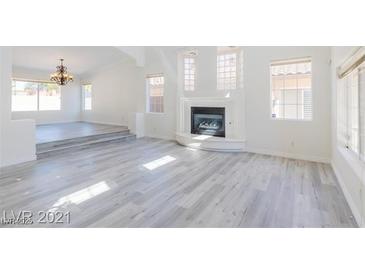 Open living room featuring a fireplace and light gray vinyl floors at 1904 Imola Ct, Las Vegas, NV 89123