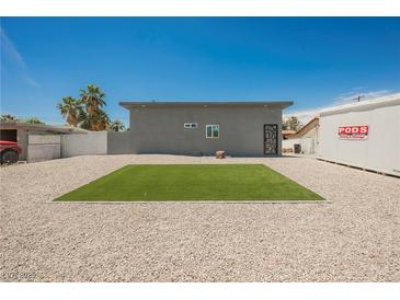 View of the home's backyard featuring gravel, a patch of grass, and a PODS moving container at 2807 Hermosa St, Las Vegas, NV 89169