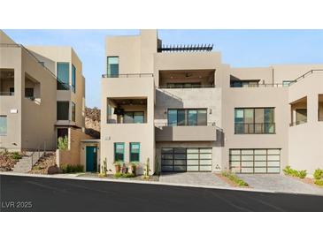 Contemporary home with multiple balconies, desert landscaping, and multi-car garage at 358 Solitude Peak Ln, Henderson, NV 89012