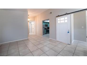 Bright living area with tile floors, open floor plan, and unique sliding barn door at 4036 E Ogden Ave, Las Vegas, NV 89110