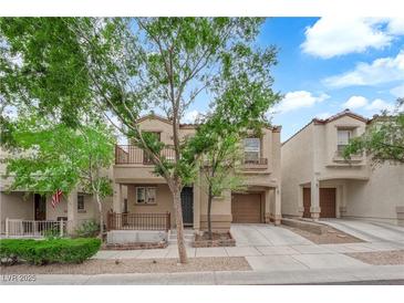 Inviting two-story home featuring a balcony, front porch, single-car garage, and well-kept landscaping at 9141 Careful Canvas Ave, Las Vegas, NV 89149