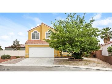 Charming two-story home featuring a well-maintained lawn, complemented by a spacious two-car garage at 1117 Coral Crystal Ct, North Las Vegas, NV 89032