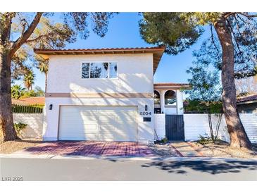 Two-story stucco home featuring a garage and private gated entrance at 2204 Plaza De La Candela, Las Vegas, NV 89102