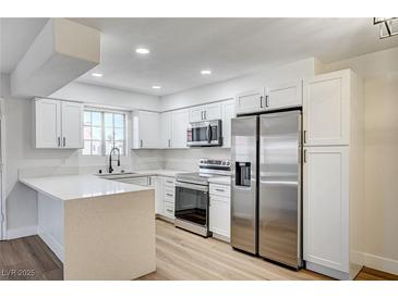 Bright kitchen featuring white cabinets, stainless steel appliances, and a large countertop at 2725 S Nellis Blvd # 2036, Las Vegas, NV 89121