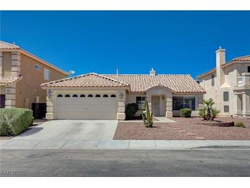 Charming single-story home with a tile roof, desert landscaping, and an attached two-car garage at 472 Staghorn Pass Ave, Las Vegas, NV 89183