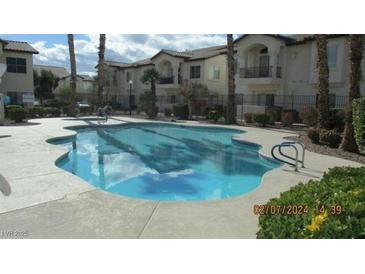 Community pool surrounded by well-maintained landscaping and nearby buildings at 4821 Black Bear Rd # 104, Las Vegas, NV 89149